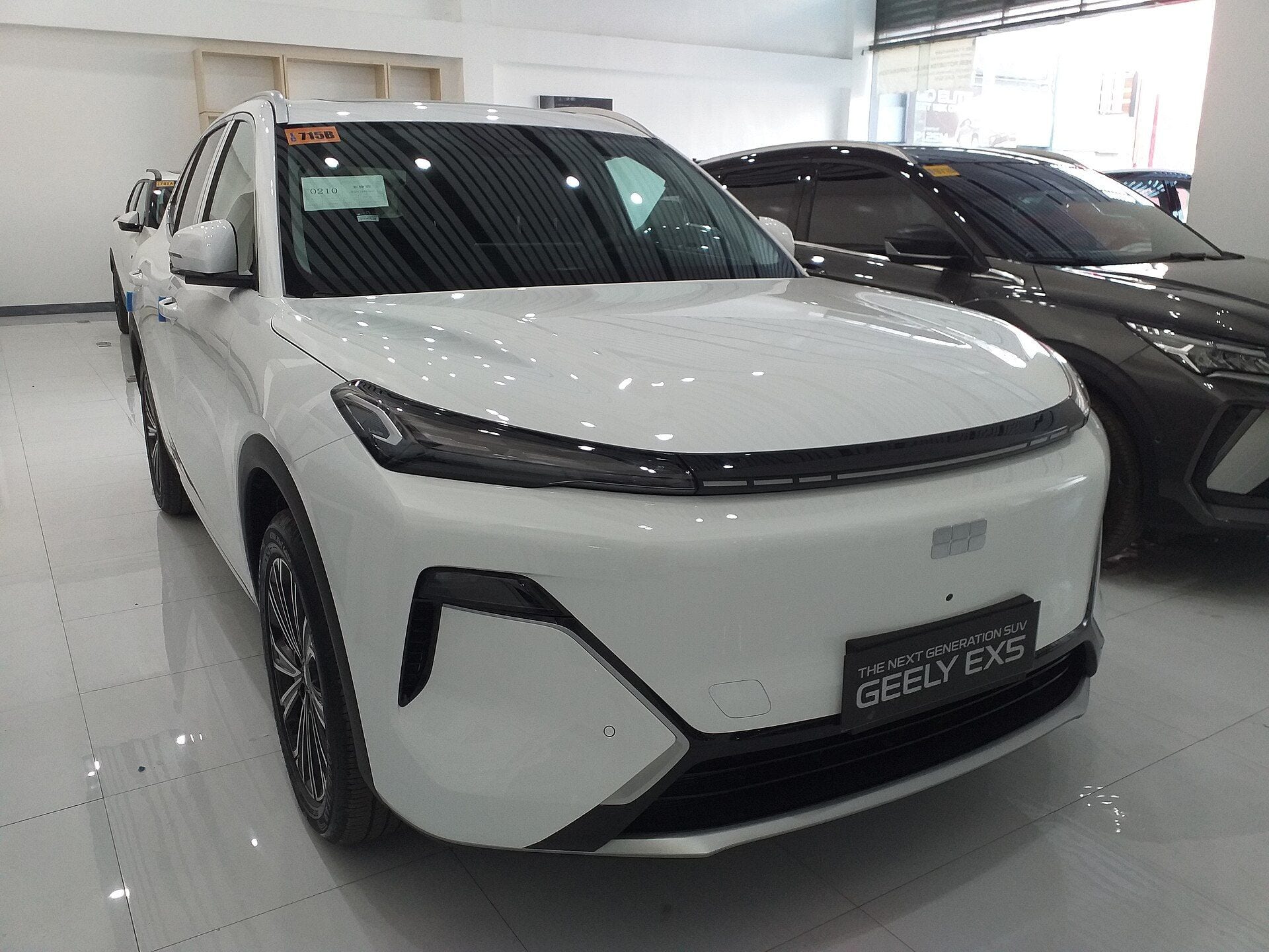 White Geely EX5 EM-i Max plug-in hybrid SUV, front three-quarter view